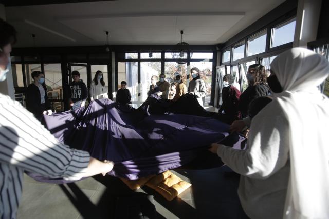 Un groupe de personnes tenant ensemble un voile en suspension