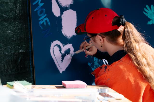 Une fille peignant un coeur mauve