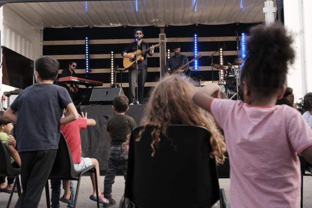 Des enfants regardant des artistes dans un camion converti en scène