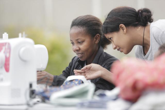 Deux femmes devant des machines à coudre