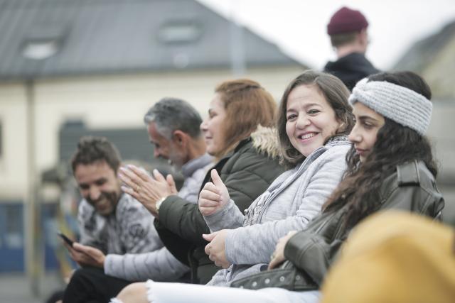 Des spectateurs assis applaudissant et souriant