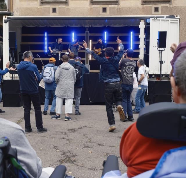 Des personnes dansant devant un camion converti en scène