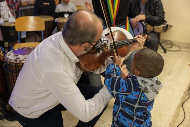 un violoniste qui montre son violon a un enfant