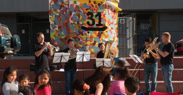 Un orchestre de cuivres jouant devant des enfants