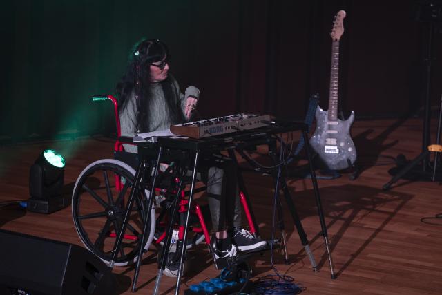 Une pianiste en fauteuil roulant sur scène