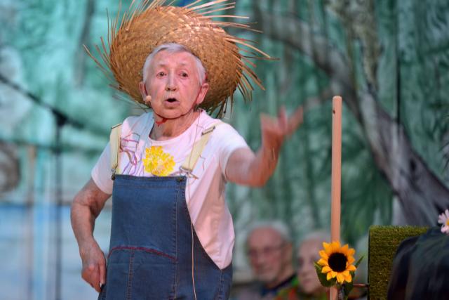 Une femme âgée en costume de paysanne sur scène
