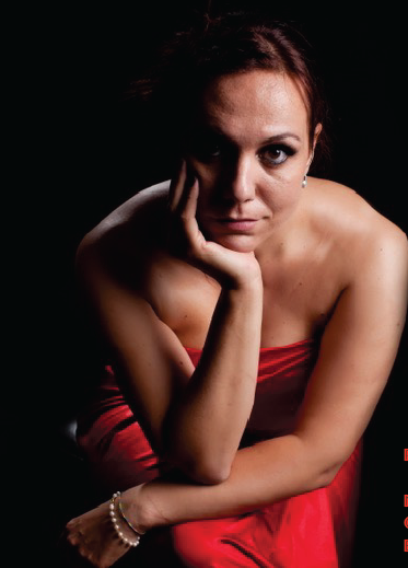 Une femme de face assise en robe rouge