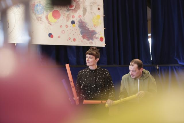 artiste et participant jouent ensemble avec des boomwhackers