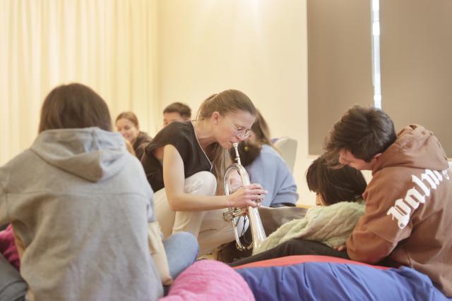 musicienne avec sa trompette devant un enfant