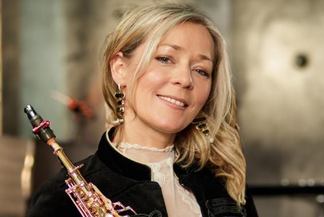 lächelnde Frau mit ihrem Saxofon